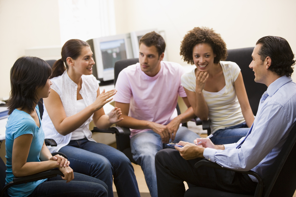 Man training four members of staff in computer room