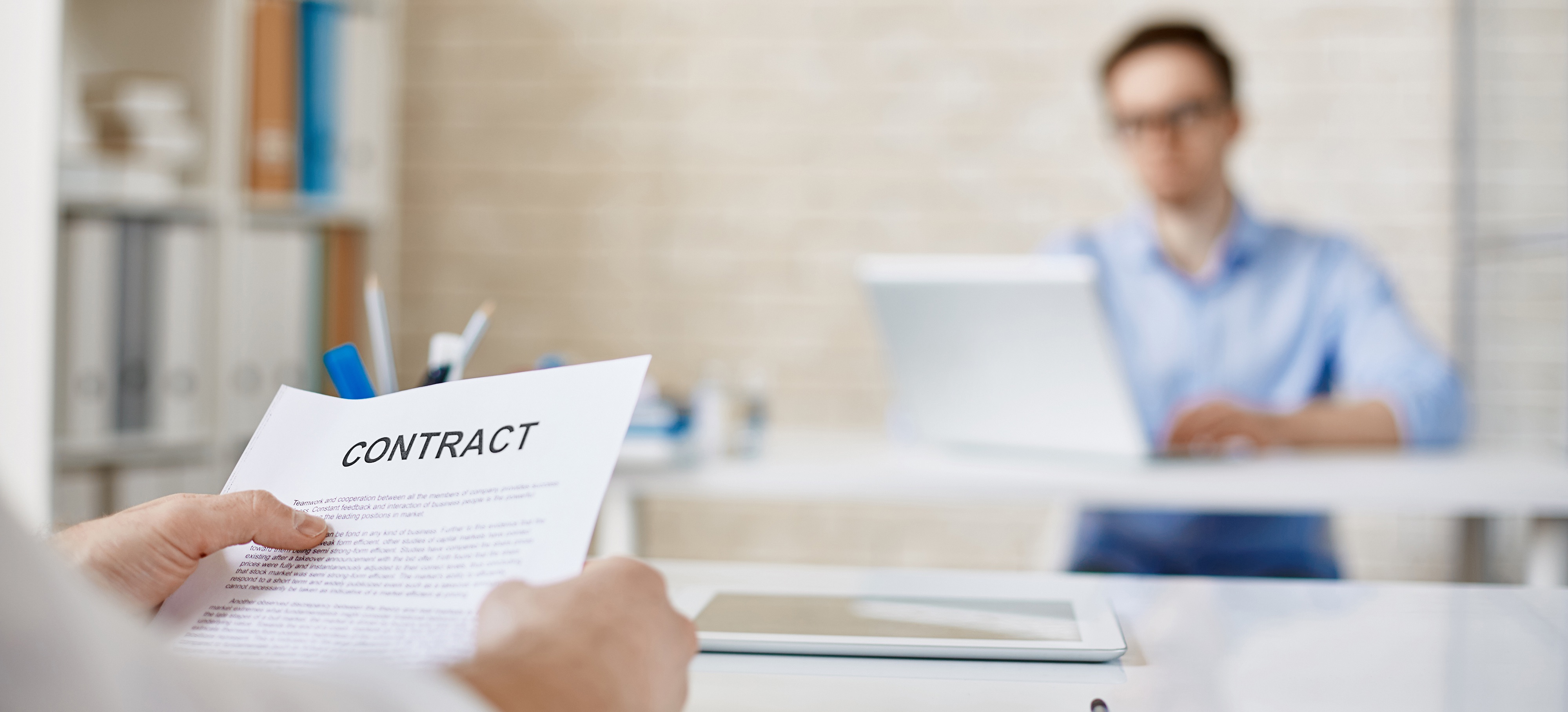 Hands holding a printed contract in workplace